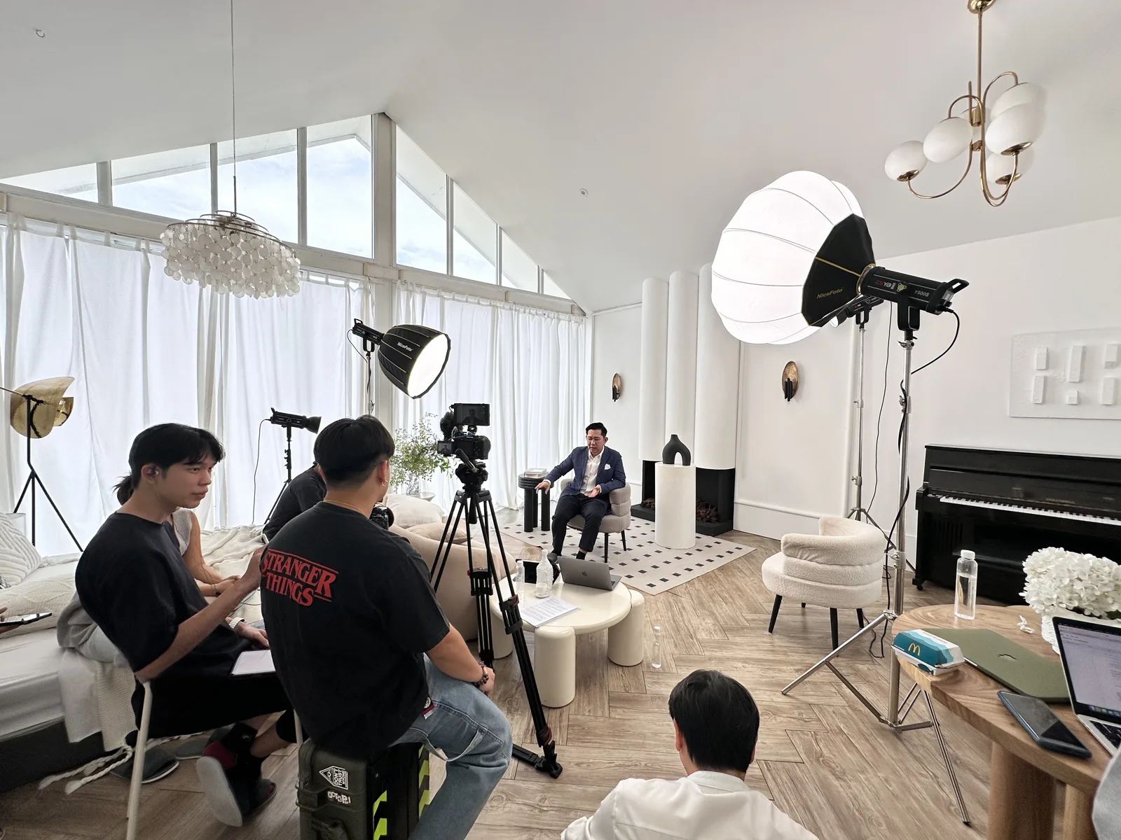 ทีมงานกำลังถ่ายทำวิดีโอสัมภาษณ์ในสตูดิโอ พร้อมอุปกรณ์ไฟและกล้องครบชุด